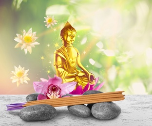 Image of Composition with incense sticks on table and Buddha figure on background