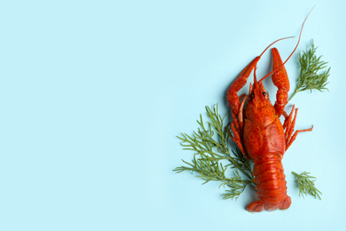 Photo of Delicious boiled crayfish and dill on light blue background, flat lay. Space for text