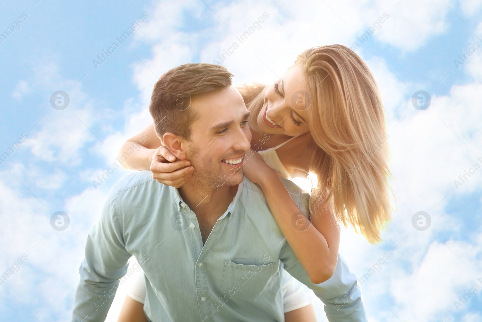 Photo of Cute young couple in love posing on light background