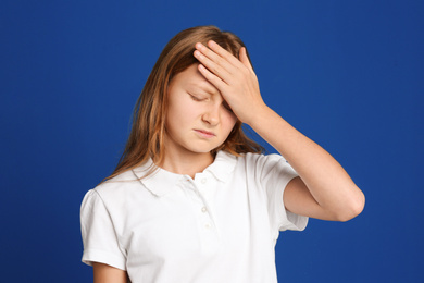 Portrait of emotional preteen girl on blue background