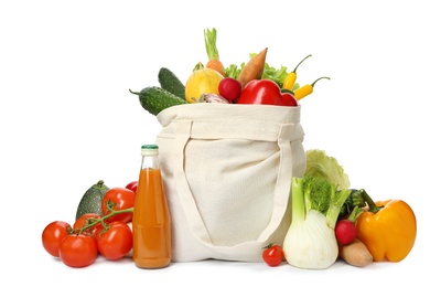 Photo of Cloth bag with fresh vegetables and bottle of juice on white background