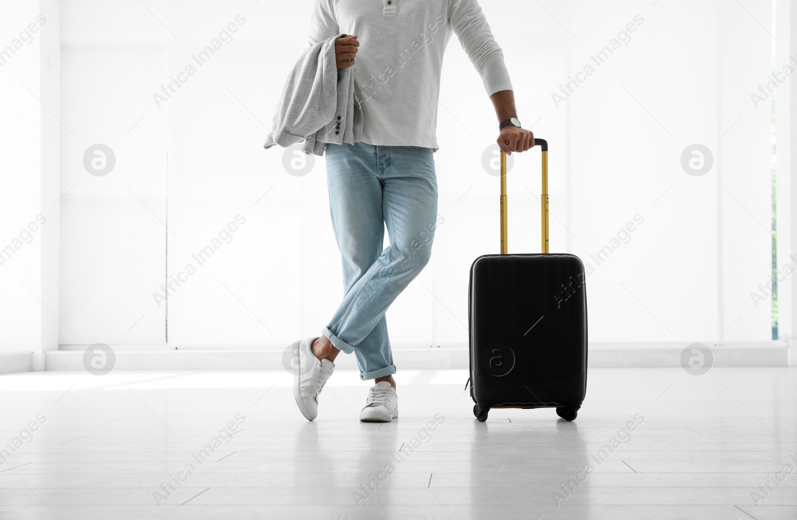 Photo of Man with black travel suitcase in airport