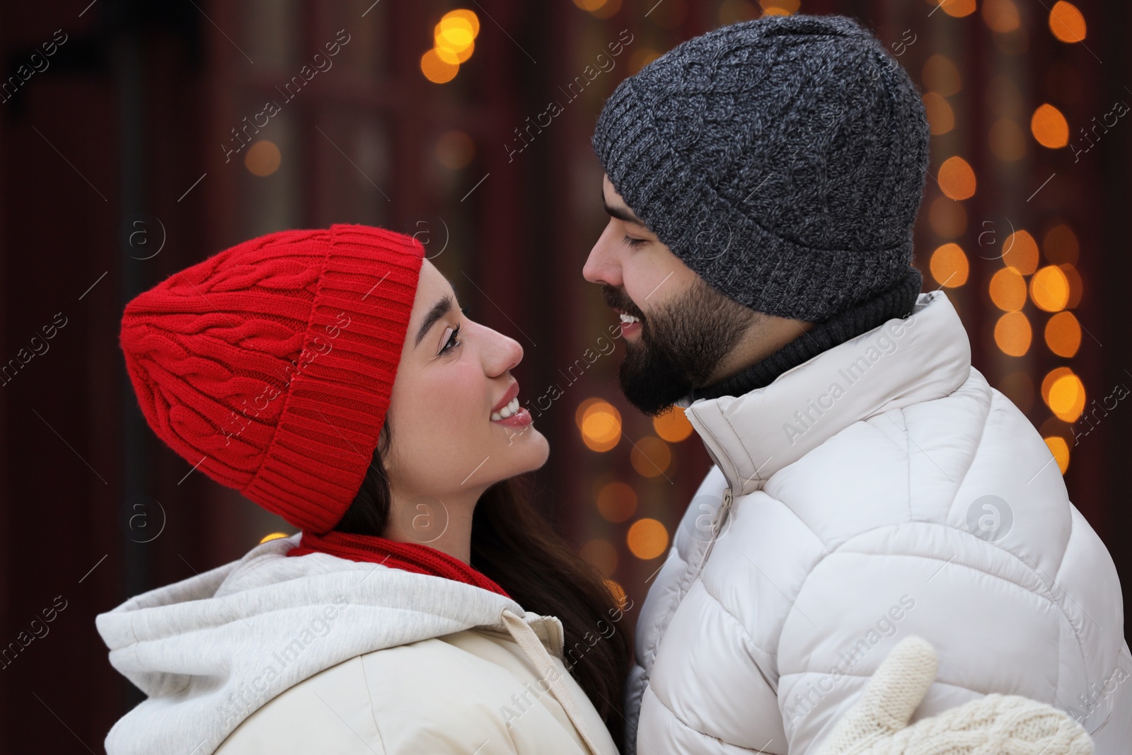 Photo of Portrait of lovely couple outdoors against blurred lights outdoors