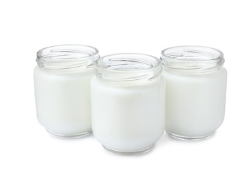 Glass jars with delicious homemade yogurt on white background