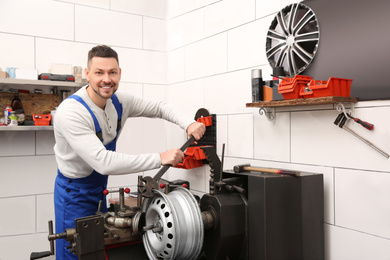 Photo of Mechanic working with car disk lathe machine at tire service