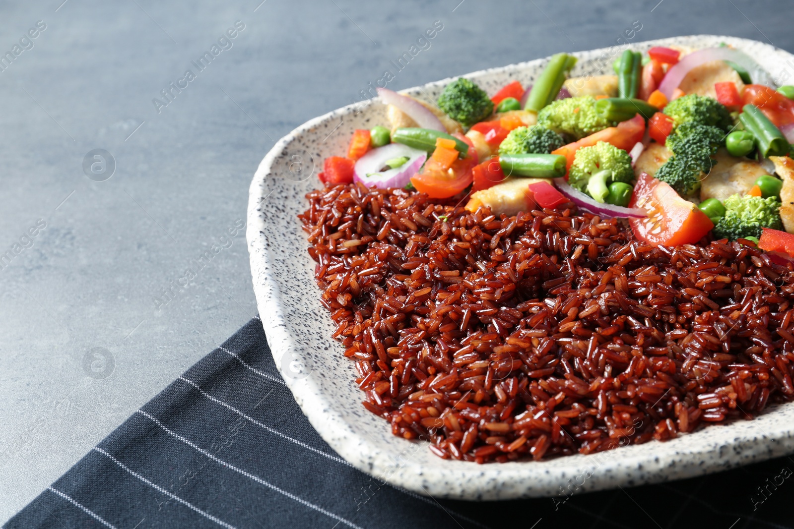 Photo of Plate with cooked brown rice on table, closeup. Space for text