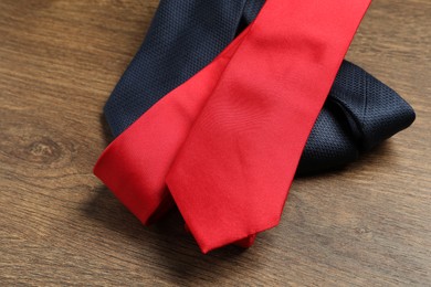 Photo of Red and blue neckties on wooden table, closeup