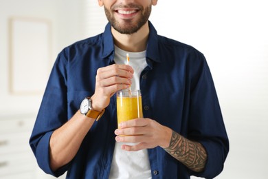 Man with delicious smoothie at home, closeup