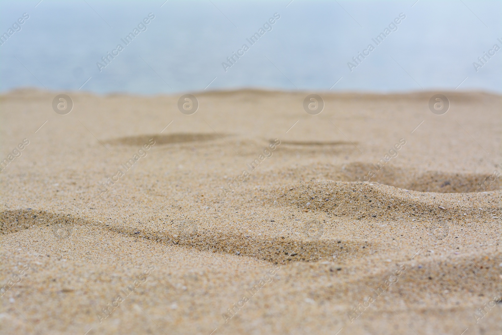 Photo of Beautiful beach with golden sand near sea, closeup view.