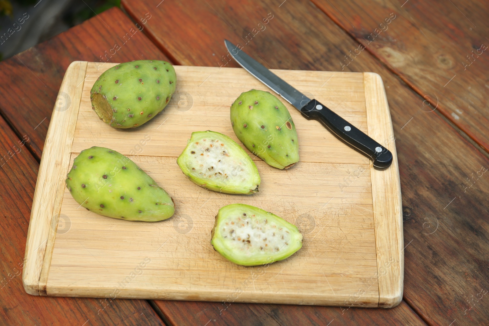 Photo of Tasty prickly pear fruits on wooden table, above view