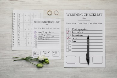Flat lay composition with Wedding Checklists and calendar on white wooden table