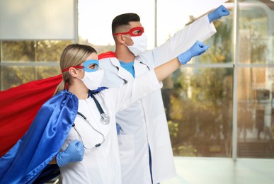 Photo of Doctors wearing face masks and capes indoors. Super hero power for medicine