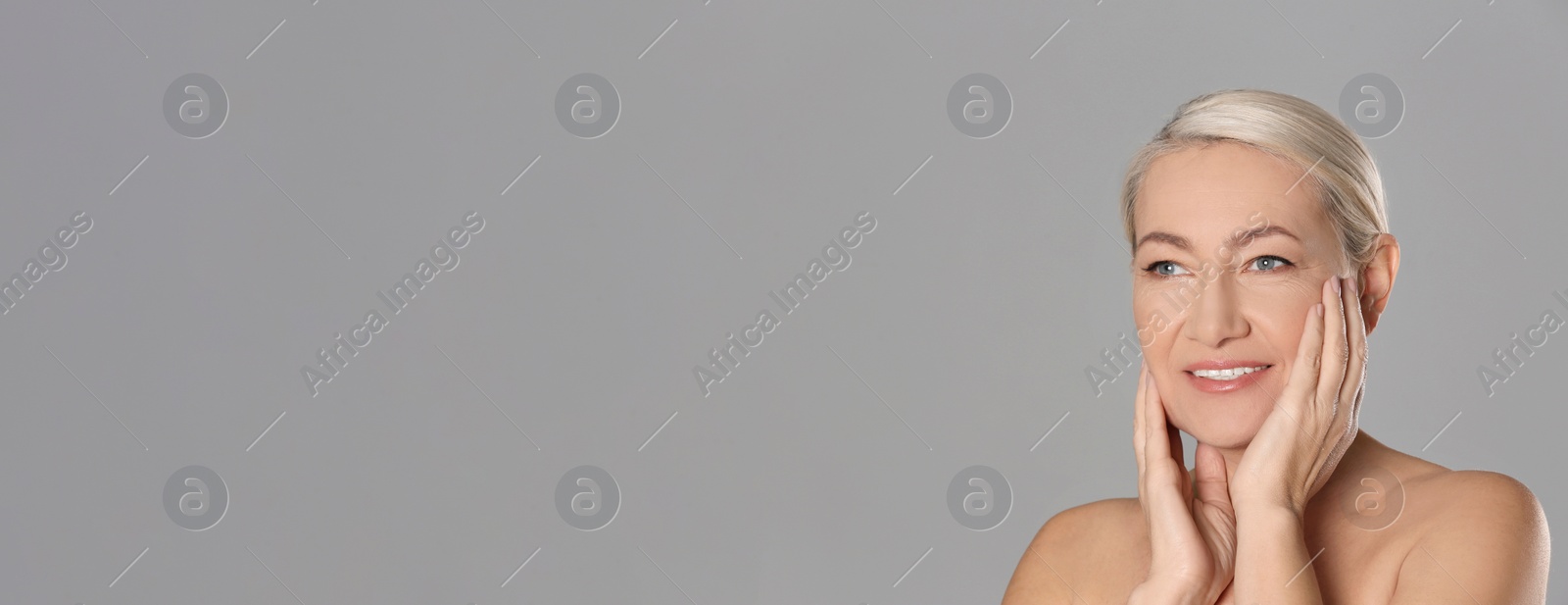 Image of Portrait of beautiful mature woman on grey background, space for text. Banner design