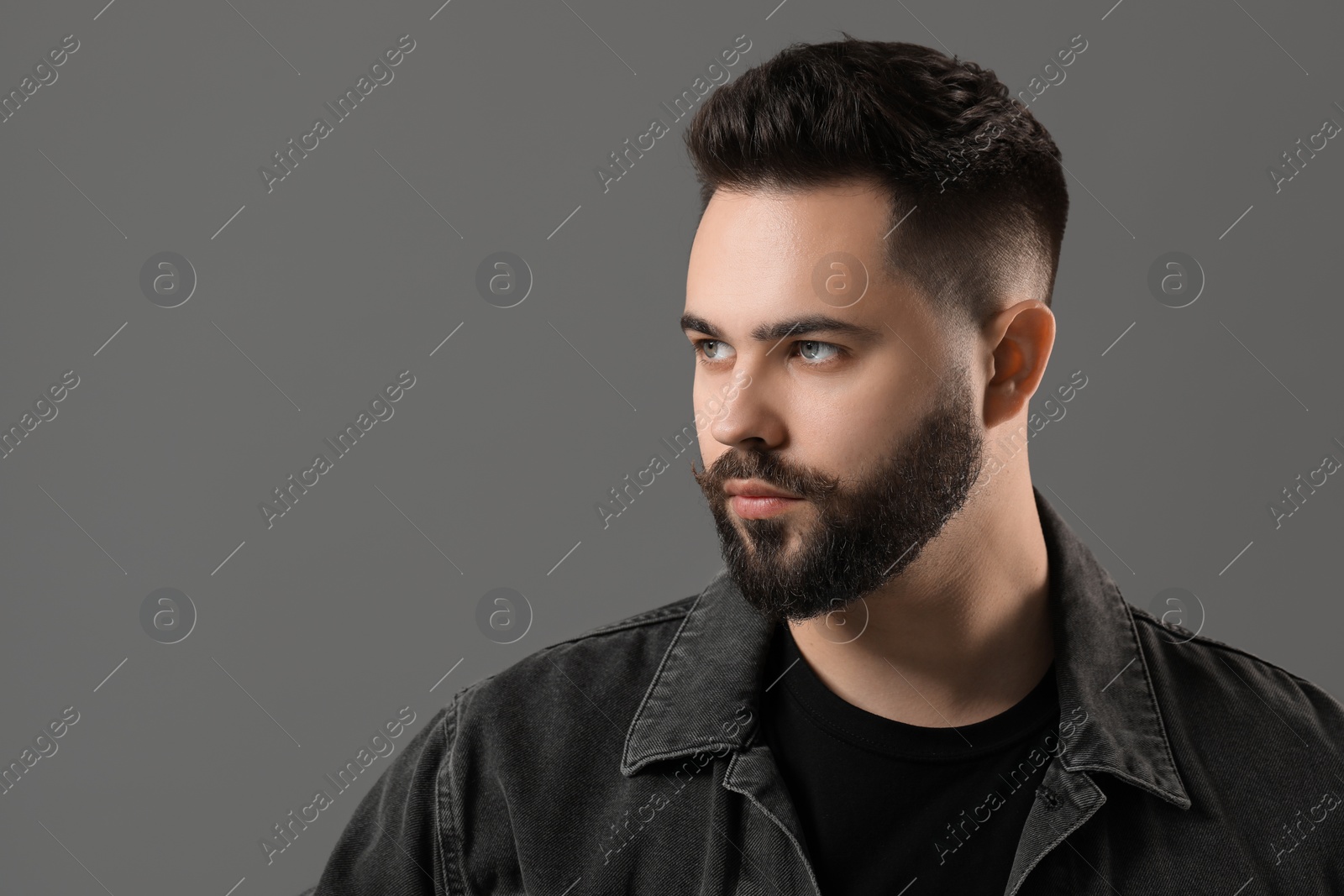 Photo of Portrait of young man with mustache on grey background. Space for text