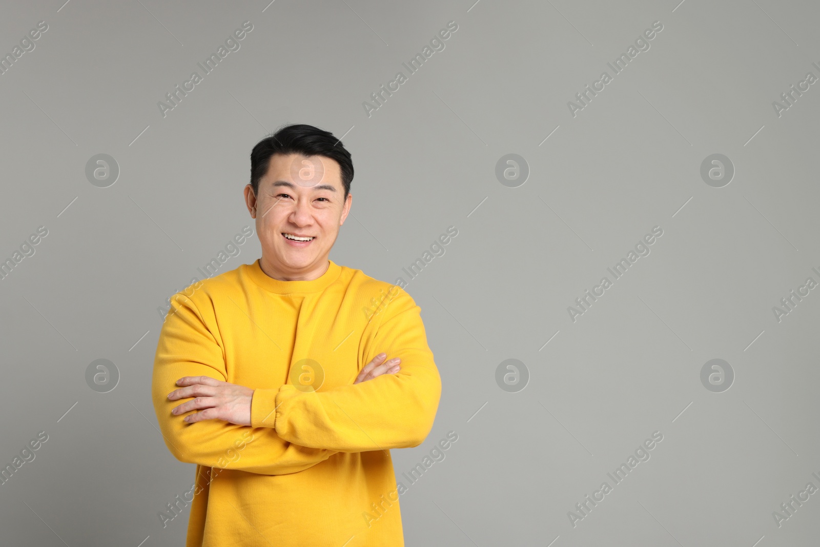 Photo of Portrait of happy man on grey background. Space for text