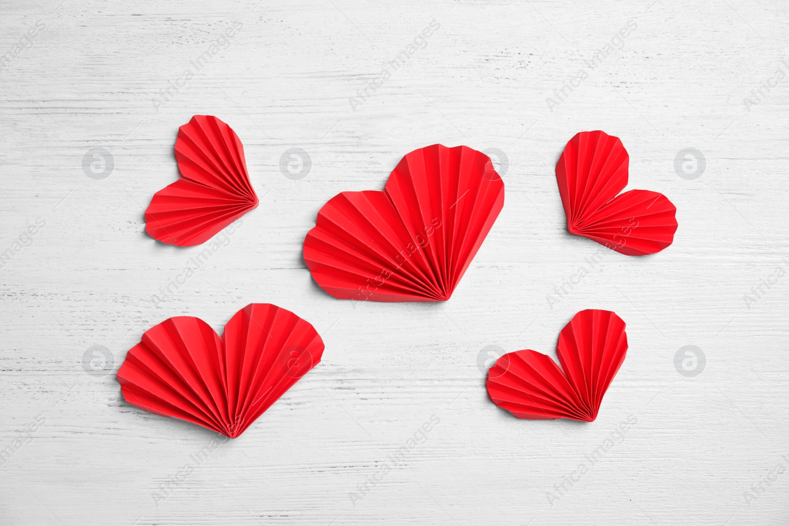 Photo of Small paper hearts on wooden background, top view