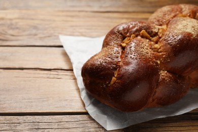 Photo of Delicious yeast dough cake on wooden table, closeup. Space for text