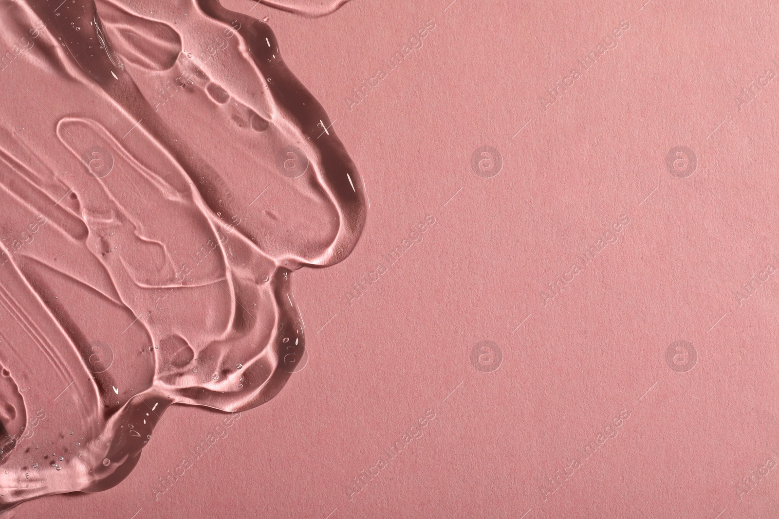 Photo of Transparent cosmetic gel on pink background, top view. Space for text