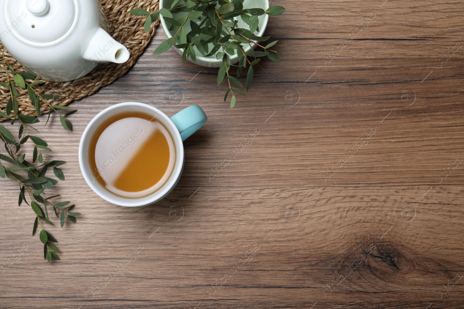 Photo of Aromatic eucalyptus tea on wooden table, flat lay. Space for text