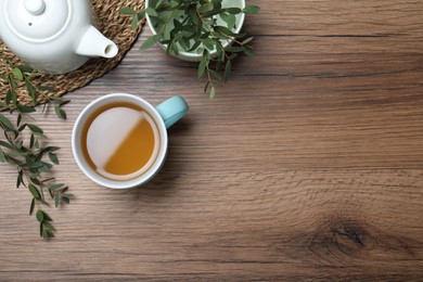 Photo of Aromatic eucalyptus tea on wooden table, flat lay. Space for text