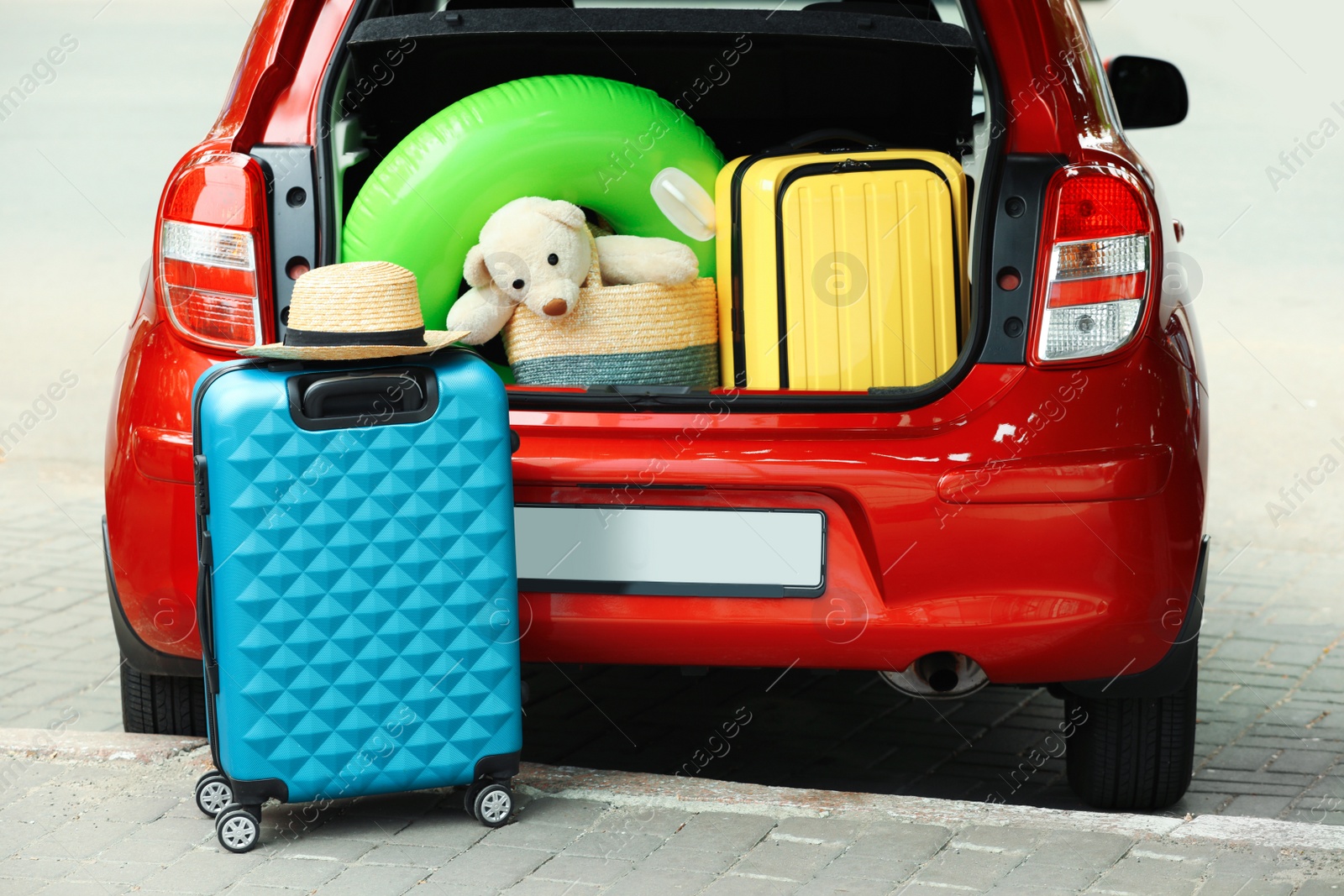 Photo of Suitcases and toys in car trunk outdoors
