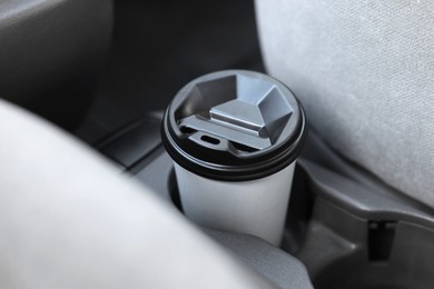 Photo of Coffee to go. Paper cup with tasty drink in holder inside of car, closeup