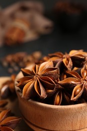 Photo of Aromatic anise stars and spices on black table, closeup