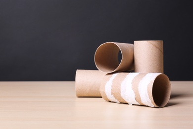 Photo of Empty toilet paper rolls on wooden table. Space for text