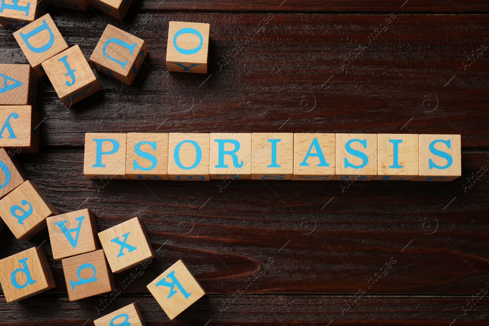 Photo of Word Psoriasis made of cubes with letters on wooden table, flat lay