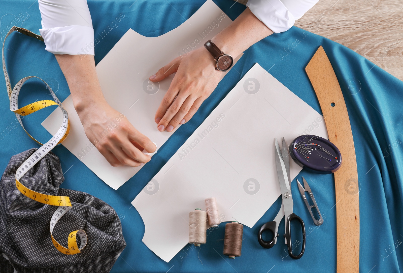 Photo of Tailor working at table in atelier, top view