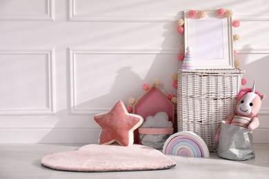 Photo of Empty photo frame and cute toys in baby room, space for text. Interior design