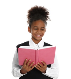 Happy African-American girl in school uniform reading book on white background