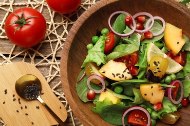 Photo of Delicious salad with peach, green peas and vegetables served on wooden table, flat lay