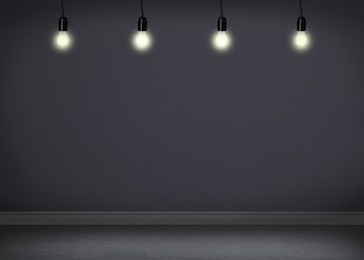 Image of Glowing light bulbs in room with grey wall and room