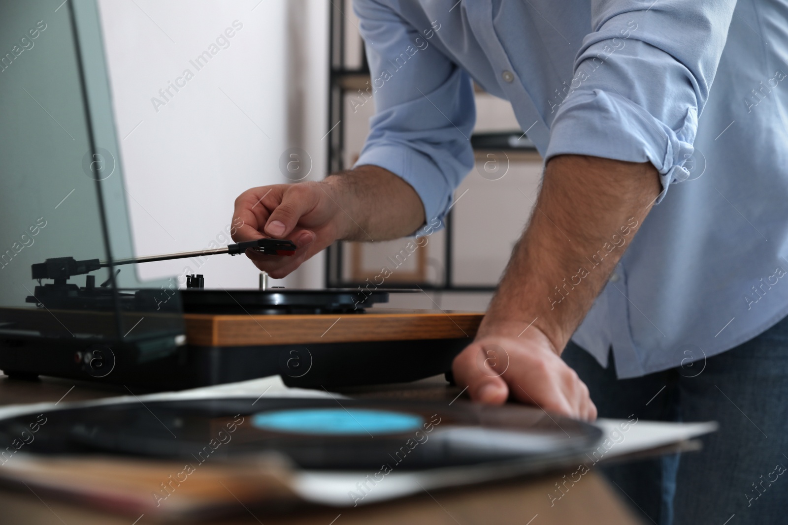 Photo of Man using turntable at home, closeup view