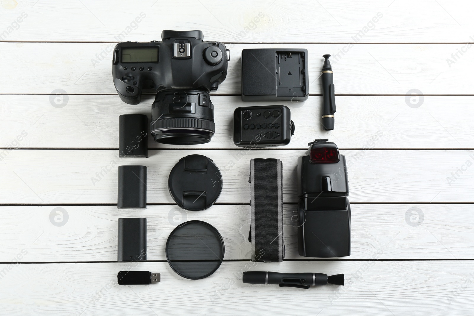 Photo of Flat lay composition with equipment for professional photographer on white wooden table