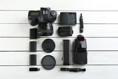 Photo of Flat lay composition with equipment for professional photographer on white wooden table