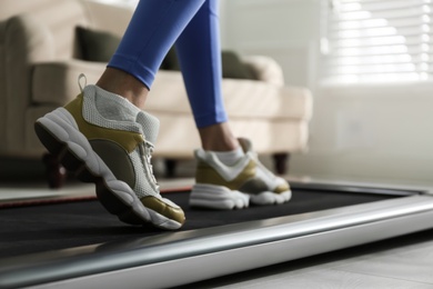 Woman training on walking treadmill at home, closeup