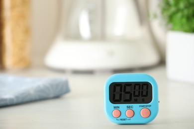 Digital kitchen timer on white table indoors. Space for text