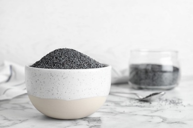 Poppy seeds in bowl on table. Space for text