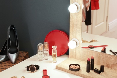 Photo of Table with makeup products and mirror, closeup. Dressing room