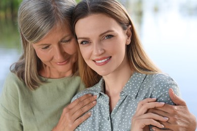 Family portrait of happy mother and daughter spending time together outdoors, closeup