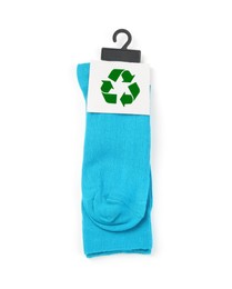 Blue socks with recycling label on white background, top view