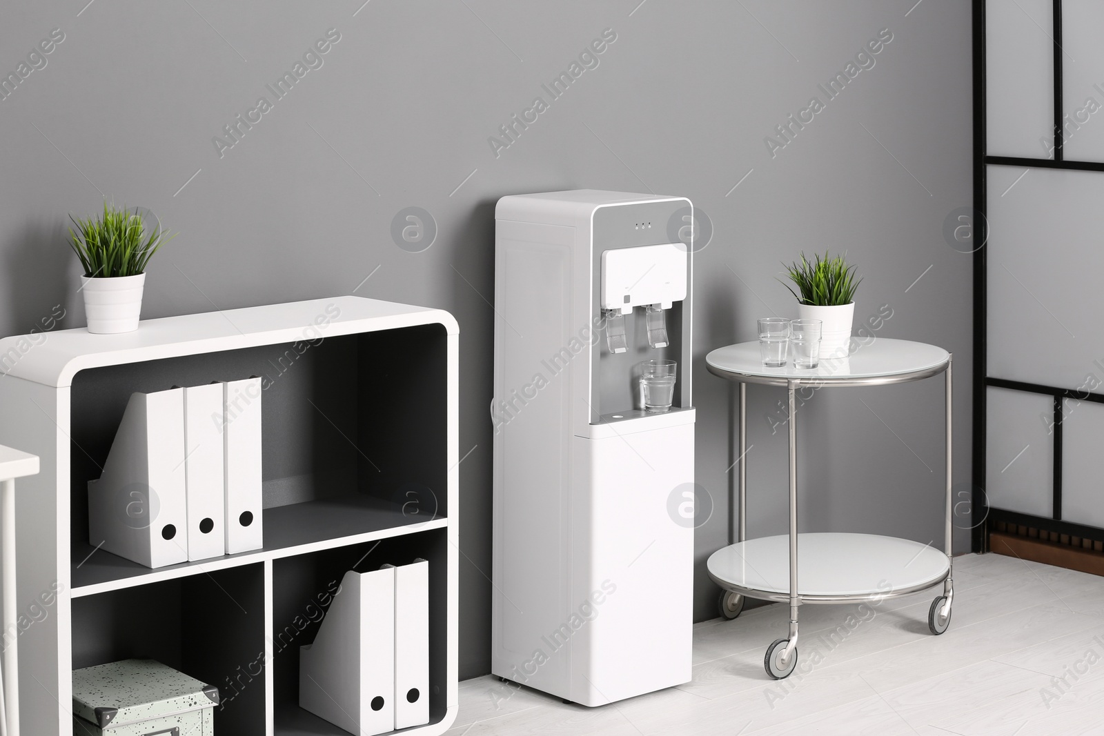 Photo of Modern water cooler in stylish office interior