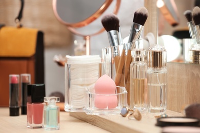 Photo of Cosmetic products, makeup accessories and jewelry on dressing table