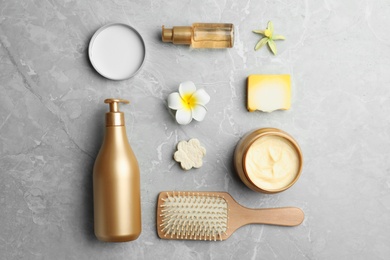 Photo of Flat lay composition with hair cosmetic products on grey marble table