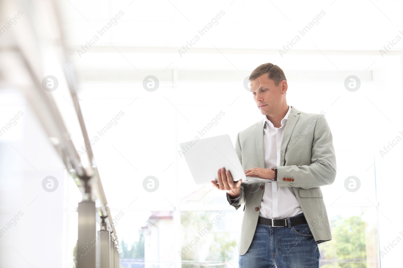 Photo of Young man working with laptop in office