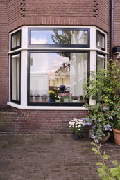 Photo of House decorated with many beautiful potted flowers, view from outside