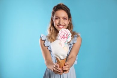 Photo of Portrait of young woman holding cotton candy dessert on blue background