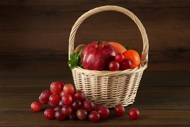 Photo of Fresh ripe fruits and wicker basket on wooden table
